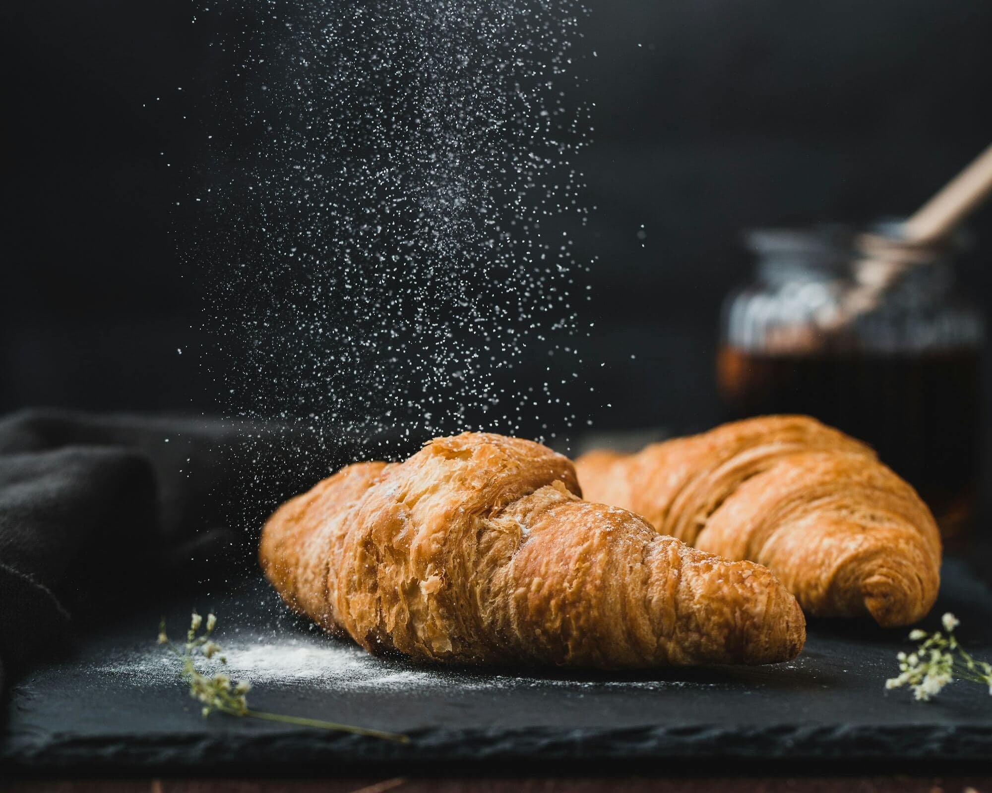 Croissants recém-saídos do forno, polvilhados de farinha